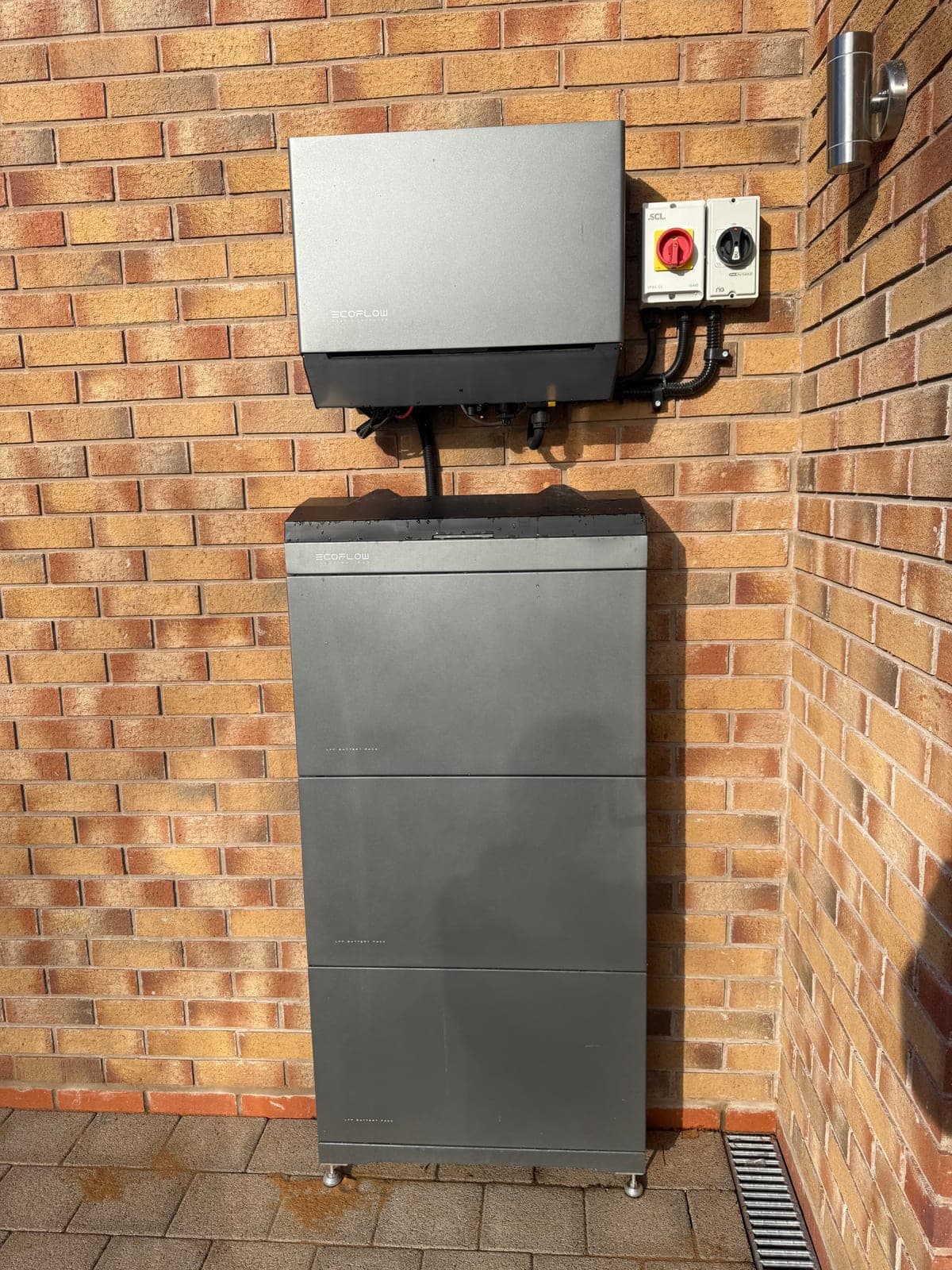 Battery storage with isolator switch on a brick patio
