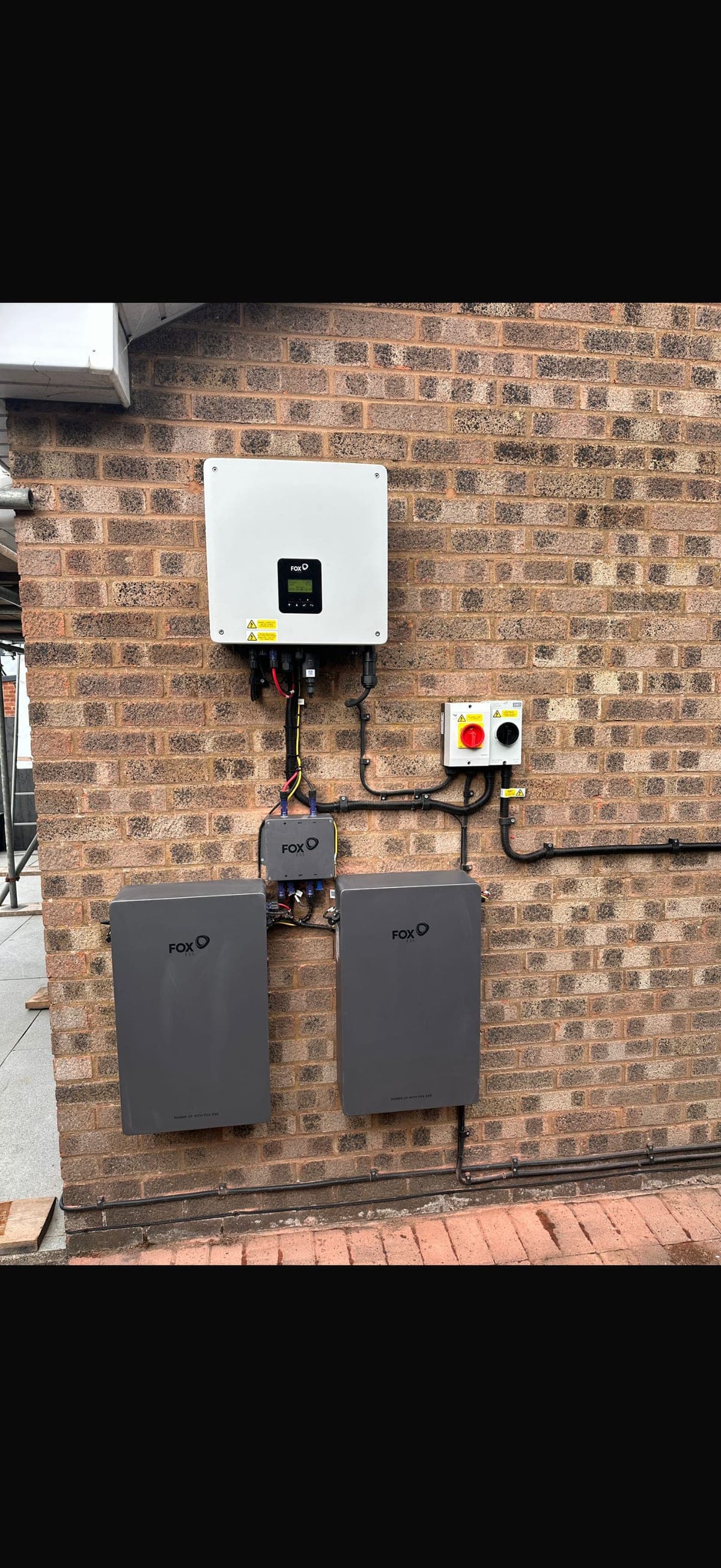 Fox battery and inverter wall-mounted on red brick