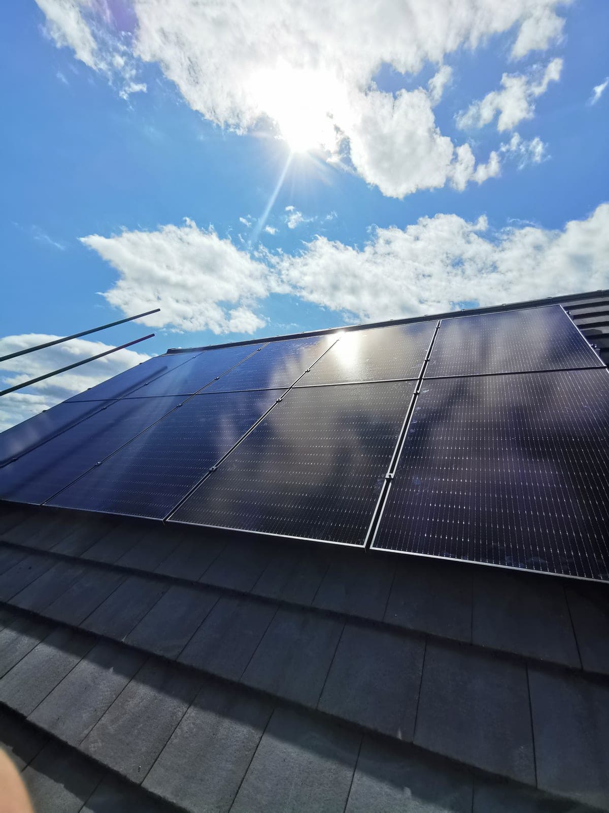 Solar panels close-up with sun flare against blue sky