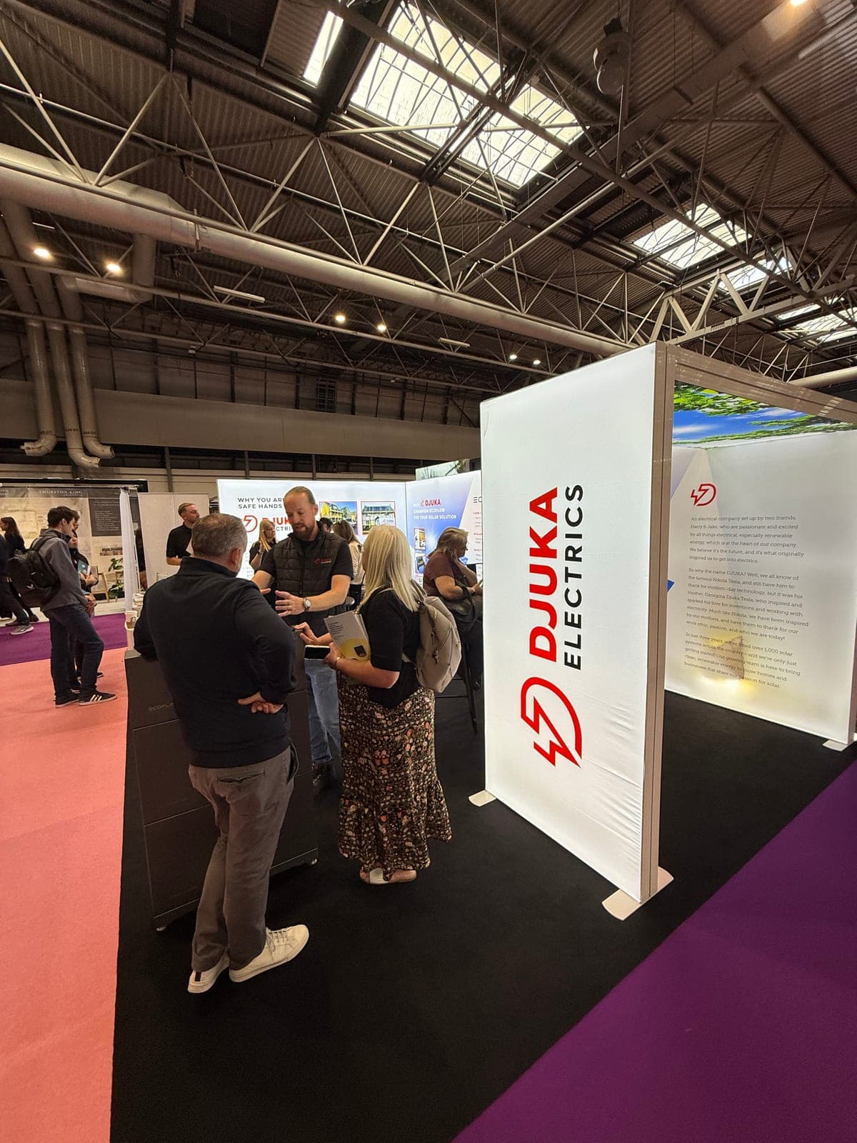 The Djuka Electrics stand with team members talking to visitors at the show
